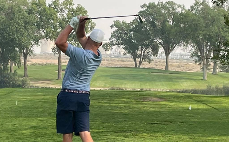golfer taking a swing on golf course 